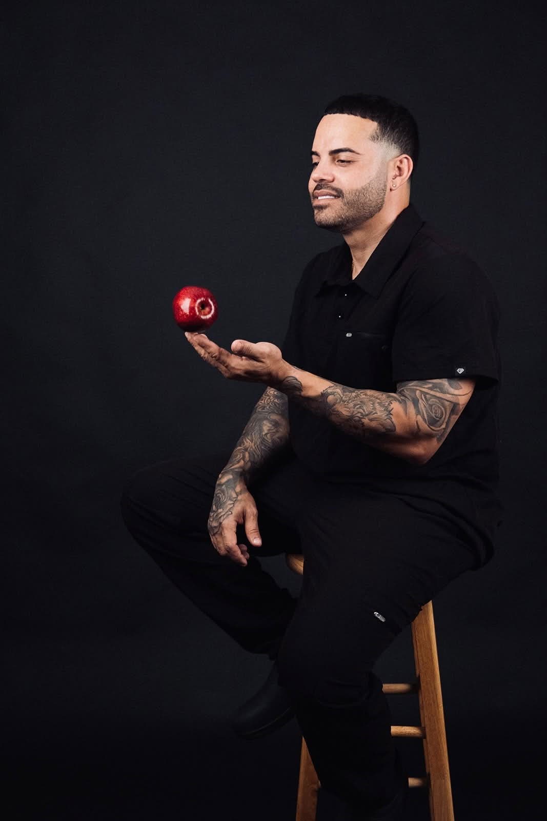 Chef Nelson Cartagena sentado sosteniendo una manzana roja
