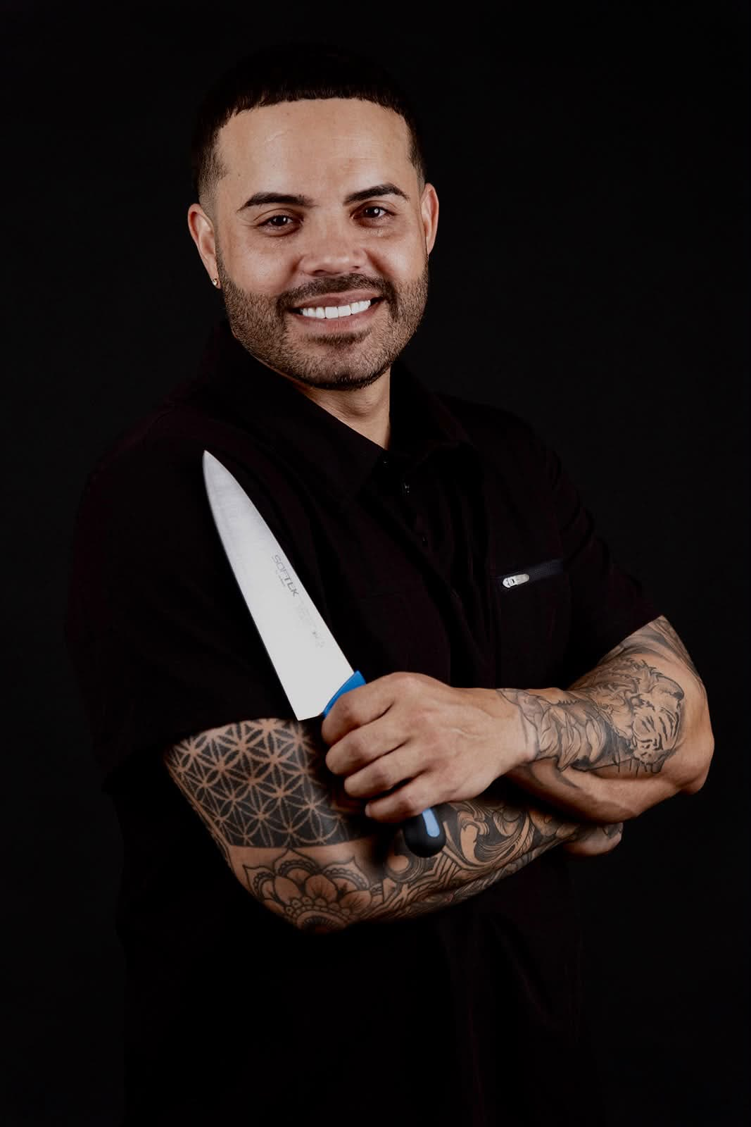 Chef Nelson Cartagena de brazos cruzados con cuchillo de chef